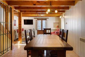 un comedor con una gran mesa de madera y sillas en Casitas centro panticosa, en Panticosa