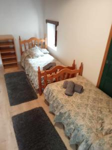- une chambre avec 2 lits jumeaux et 2 tapis dans l'établissement Casitas centro panticosa, à Panticosa