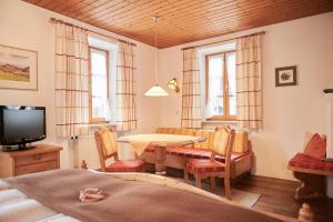 a living room with a table and chairs and a television at Haus Ranker in Reit im Winkl