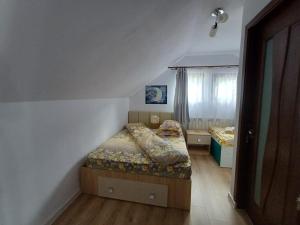 a small bedroom with two beds and a window at Cabana Acasă la Delia in Gîrda de Sus