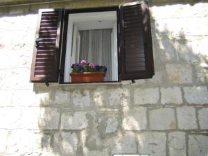 una ventana con una maceta en una pared de piedra en Apartment Sweet Home en Split
