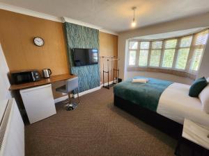 a hotel room with a bed and a tv at Solihull Shared House in Birmingham