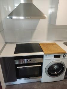 una cucina con piano cottura e lavatrice di WANDA Patrimonio parking gratis LICENCIA TURISTICA VT-13975 ad Alcalá de Henares