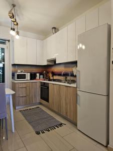 a kitchen with a white refrigerator and wooden cabinets at Apartment Lux Zadar in Zadar