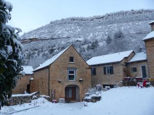 a brick house in the snow with a mountain in the background at Gîte le Nid du Colibri - 12 pers in Brenoux