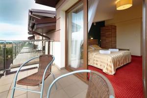 balkon z łóżkiem i krzesłem w pokoju w obiekcie Hotel Czardasz w mieście Luzino