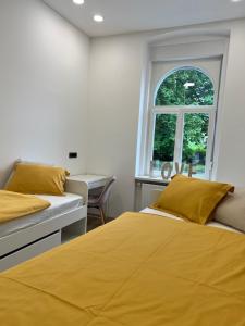 a bedroom with two beds and a window at City Apartment Chiara in Maribor