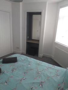 a bedroom with a large bed and a mirror at J & S Apartments in Ayr