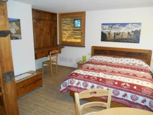 Un dormitorio con una cama y un escritorio. en La Luge, en Saint-Christophe