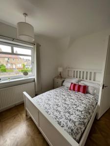1 dormitorio con 1 cama grande y ventana en St Andrews Holiday Home en Fife