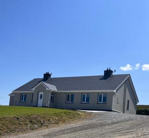 a large white house on a dirt road at The Collins,Our View from The Top in Listowel