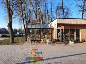 a building with a table and chairs in a park at Danės Apartamentai in Klaipėda