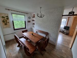 a dining room with a wooden table and chairs at Ubytování - Černá hora II in Svoboda nad Úpou