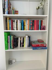 a book shelf filled with lots of books at Spacious 4 BR House w/Parking in Birmingham