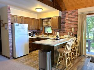 La cuisine est équipée d'un réfrigérateur blanc et de placards en bois. dans l'établissement The House that Jack Built, à Moran