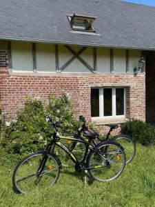 two bikes parked in front of a brick house at Le Clos Charmaine in Auquemesnil