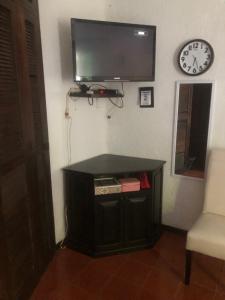 Habitación con TV, mesa y reloj. en Casablanca, en Cancún