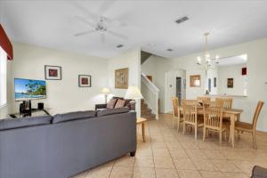 a living room and dining room with a couch and a table at Regal Palms Lovely 3 Br Sleeps 8mins To Disney in Davenport