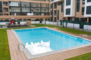 a large swimming pool in front of a building at La Figar,apartamento con piscina, playa a 3km VUT-4390-AS in Llanes +4 photos