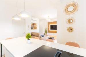 uma cozinha e sala de estar com paredes brancas e uma mesa em Expoholidays- Apartamento Federico García Lorca em Almeria
