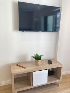 a wooden table with a tv on a wall at CP luxury studio in Gibraltar