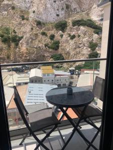 a table and a chair on a balcony with a view at CP luxury studio in Gibraltar