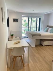 Schlafzimmer mit einem Bett, einem Schreibtisch und einem Tisch in der Unterkunft CP luxury studio in Gibraltar