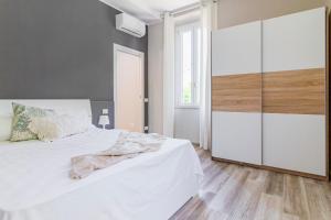 a bedroom with a white bed and a large closet at L'amoruccio in Belvedere Inferiore