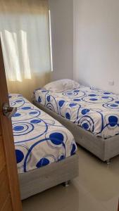 2 camas individuales en una habitación con 3 camas individuales que establece que en Hermoso apartamento en el corazon del carnaval, en Barranquilla
