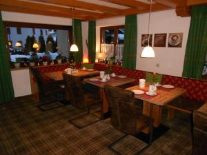 a dining room with wooden tables and chairs at Gästehaus Weißes Rössl in Reit im Winkl