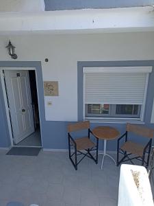 una stanza con due sedie e un tavolo e una finestra di Seven Seas Apartments a Artemida