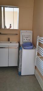 a small white refrigerator in a room with a window at Le Continental in Vittel