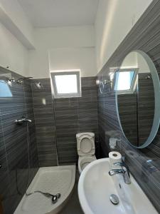 a bathroom with a sink and a toilet and a mirror at Vila Eriseld in Ksamil +23 photos