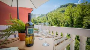 een fles wijn zittend op een tafel met twee glazen bij L'amoruccio 