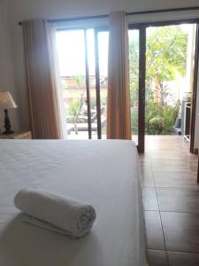 ein weißes Bett mit einem Handtuch in einem Schlafzimmer in der Unterkunft Private room in Damar Bali Guest house in Kerobokan