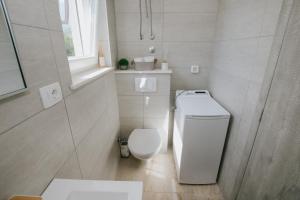 カシュテラにあるRoyal Blue House 1のトイレと窓のある白いバスルーム