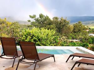 two chairs sitting next to a swimming pool at Statera Host - Pousada de Bem-Estar in Alto Paraíso de Goiás