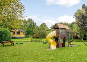 a small playground with a slide and a house at Ashlea Pools Lodges in Broome