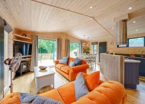 a living room with orange furniture and a kitchen at Ashlea Pools Lodges in Broome