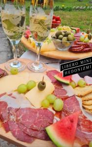 a table with glasses of wine and cheese and fruit at Libero house in Smederevo