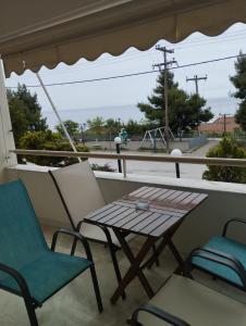 una mesa y sillas en un porche con vistas a un parque infantil en Seaview to Olympus, sunny, cosy apartment, en Néa Michanióna