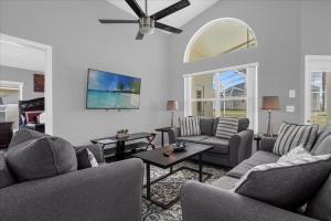 a living room with couches and a ceiling fan at Amazing 4 Bedrooms 3 Bath with private pool, near Disney and Universal! in Davenport