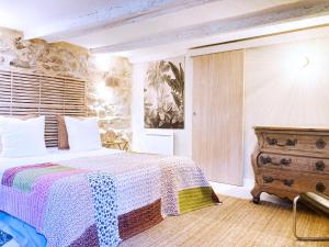 サン・ローラン・デ・ザルブルにあるRésidence du Plataneのベッドルーム1室(ベッド1台、木製ドレッサー付)