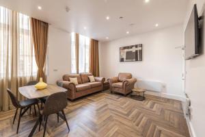 a living room with a couch and a table and chairs at The Pocklington - The Guild Suite in Leicester