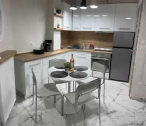 a kitchen with a table with chairs and a refrigerator at Studio Coral by the sea in Neoi Epivates