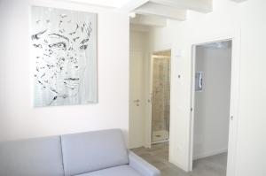 una sala de estar con sofá y una pintura en la pared en La Casa Incartata, en Toscolano Maderno