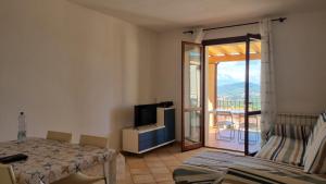 a room with a bed and a television and a balcony at Appartamento Blu Relax in Capoliveri