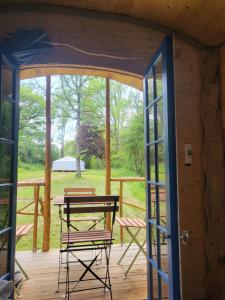 a porch with a table and chairs on a deck at L'alternatif in Huriel