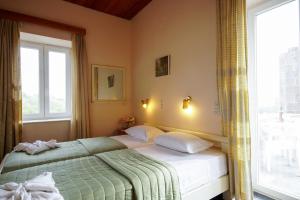 um quarto com uma cama e uma grande janela em Ιρις em Mithimna