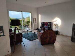 a living room with a person sitting in a chair at Maison du phare. in Plouarzel